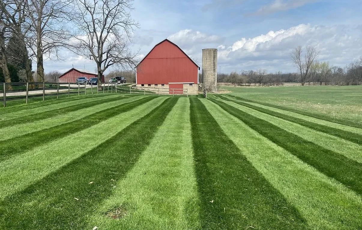 Striped farm lawn with red barn in Greenville OH